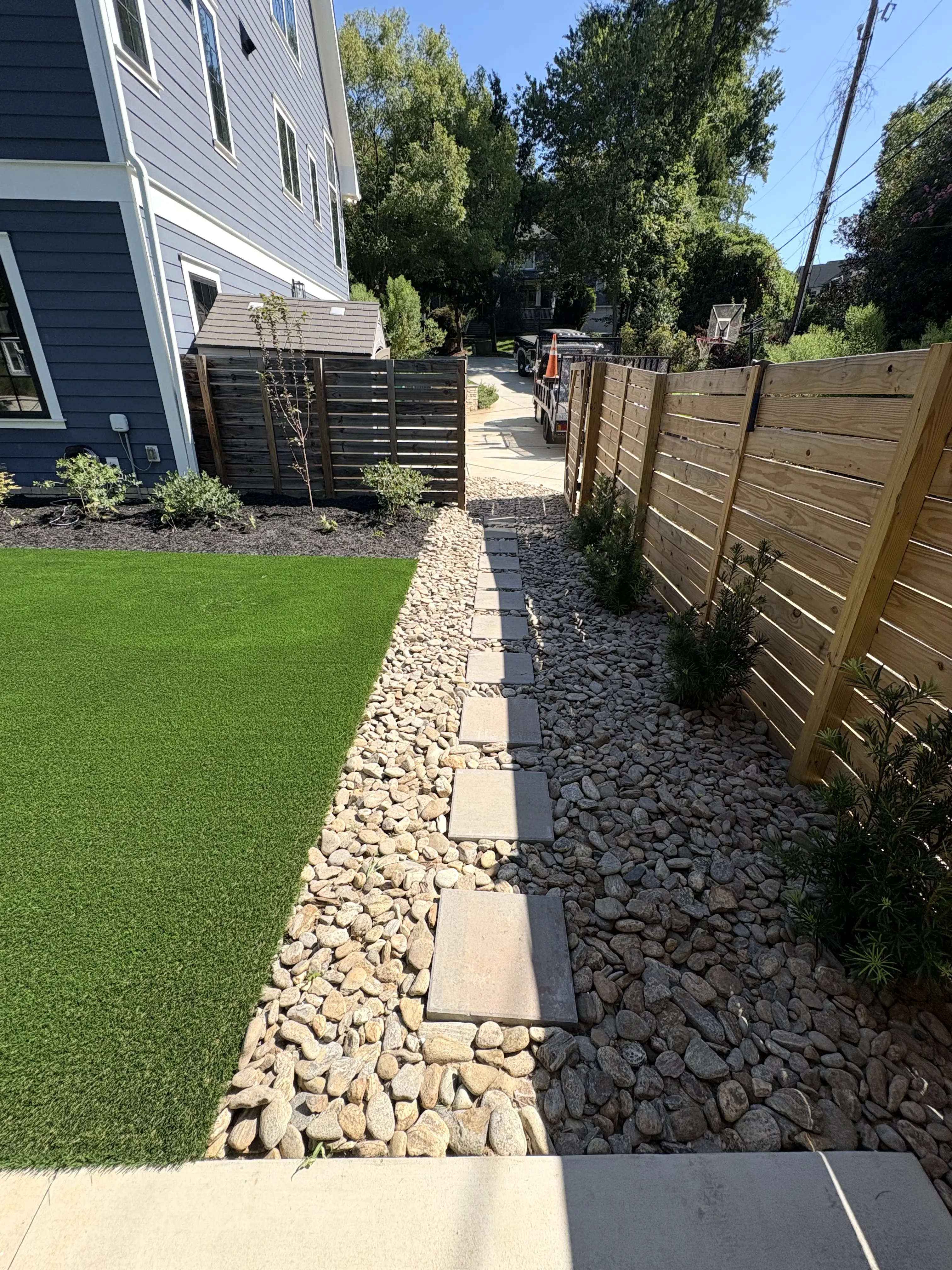 Side yard turf with river rock pathway — Charlotte NC